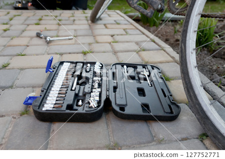 Bicycle maintenance: A close-up of a multitool and tools next to a bike wheel, ready for repair and service in a workshop 127752771