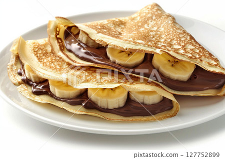 Crepes stuffed with chocolate spread and banana on white plate 127752899