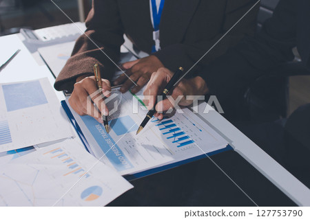 Focused young businessman signing agreement with skilled lawyer in eyeglasses. Concentrated financial advisor showing place for signature on paper contract document to male client at meeting in office Focused young businessman signing agreement with skilled lawyer in eyeglasses. Concentrated financial advisor showing place for signature on paper contract document to male client at meeting in office 127753790