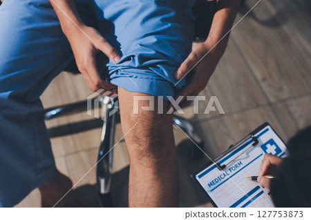Physical therapist teaching a patient how to do exercises for his knee pain Physical therapist teaching a patient how to do exercises for his knee pain 127753873