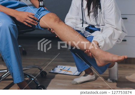 Physical therapist teaching a patient how to do exercises for his knee pain Physical therapist teaching a patient how to do exercises for his knee pain 127753874
