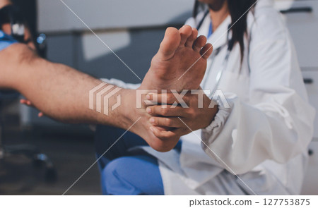 Physical therapist teaching a patient how to do exercises for his knee pain 127753875