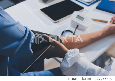 Doctor checking patient arterial blood pressure in hospital. Health care Concept 127753880