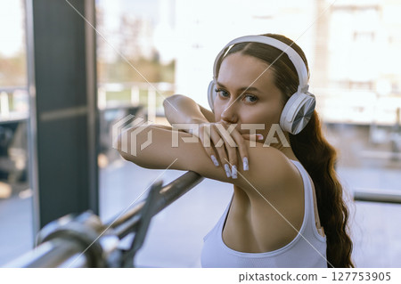 Sexy girl wearing sportswear is posing next smith machine in the fitness center. 127753905