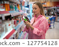 Customer using smartphone scanning product in supermarket 127754128