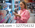 Customer scanning product with smartphone in supermarket 127754132