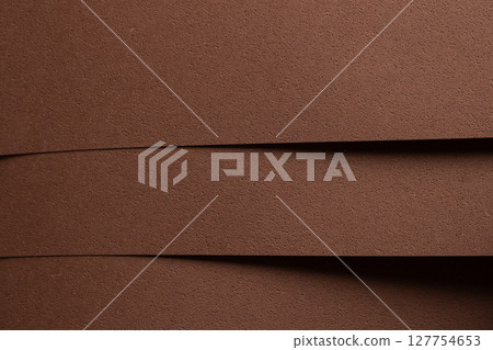 Close up background of designer paper in chocolate brown tones with spongy perforated texture and 127754653