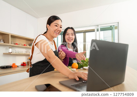 Cooking Class: Women Using Laptop for Recipe Inspiration 127754809