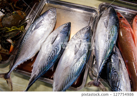 Asian fish market, fresh mackerel fish and seafood displayed for sale Asian fish market, fresh mackerel fish and seafood displayed for sale 127754986
