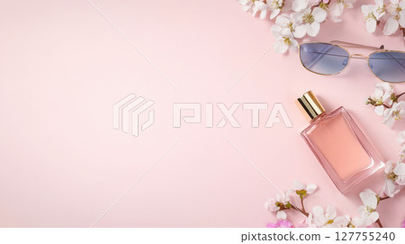 Elegant top view of perfume bottle and floral accents in soft pastel tones, styled for cosmetic or fashion advertising. 127755240
