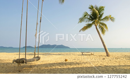 Seductive woman swinging on a swing on a tropical beach, on shores of the turquoise sea. Concept travel, walks, rest in sea, tropical resort coastline relaxation traveling tourism summer holidays. 127755242