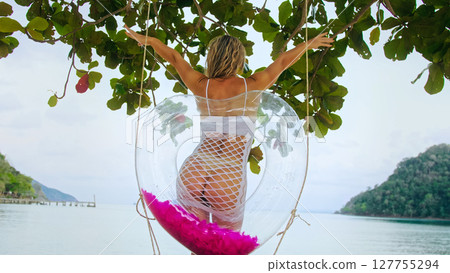 Sexy playful woman posing near a swing with an inflatable heart. Luscious girl spends her vacation at the sea. Concept natural beauty body positive, femininity and sexuality, travel erotica Sexy playful woman posing near a swing with an inflatable heart. Luscious girl spends her vacation at the sea. Concept natural beauty body positive, femininity and sexuality, travel erotica 127755294