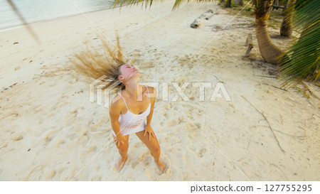 The tanned woman dances cool and appetizing on the beach of Koh Chang island in Thailand. Booty dancing twerk. Concept travel, walks, rest in sea, tropical resort traveling tourism summer holidays The tanned woman dances cool and appetizing on the beach of Koh Chang island in Thailand. Booty dancing twerk. Concept travel, walks, rest in sea, tropical resort traveling tourism summer holidays 127755295