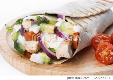 A delicious grilled chicken wrap with vegetables and avocado A delicious grilled chicken wrap with vegetables and avocado 127755694