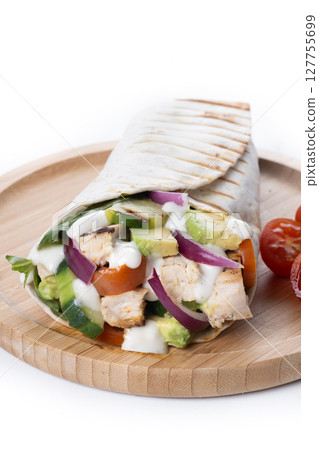 A delicious grilled chicken wrap with vegetables and avocado 127755699