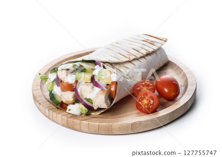 A delicious grilled chicken wrap with vegetables and avocado 127755747