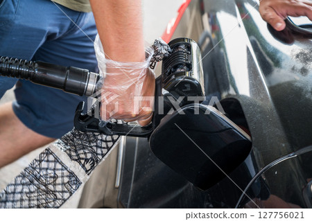 Man driver hand refilling the car with fuel at the gas petrol station. Man driver hand refilling the car with fuel at the gas petrol station. 127756021