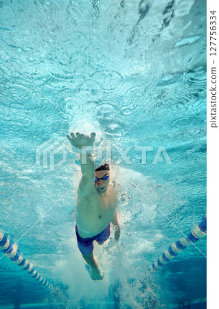 Underwater view of swimmer performing freestyle stroke in pool Underwater view of swimmer performing freestyle stroke in pool 127756334
