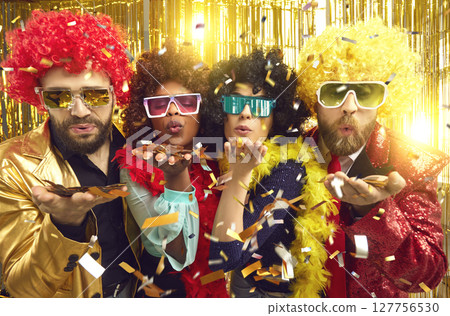 Happy diverse people in glasses and wigs blowing kiss with golden confetti at disco party 127756530