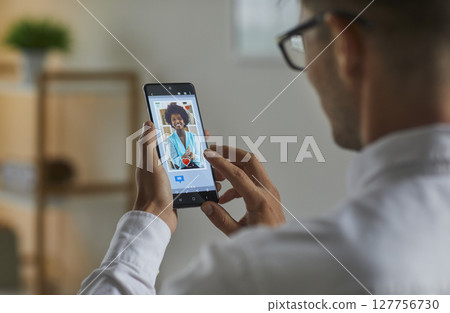 Man gives like to young woman's profile picture on online dating app or web site Man gives like to young woman's profile picture on online dating app or web site 127756730