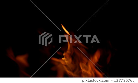 Captivating and mesmerizing Flames dance vibrantly against a Dark Background, creating allure 127756763