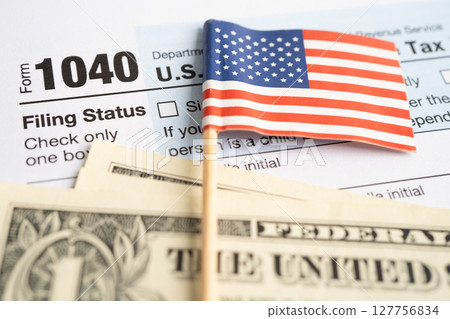 Tax Return form 1040 with USA America flag and dollar banknote, U.S. Individual Income. 127756834