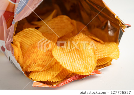 Potato chips, delicious BBQ seasoning spicy for crips, thin slice deep fried snack fast food in open bag. Potato chips, delicious BBQ seasoning spicy for crips, thin slice deep fried snack fast food in open bag. 127756837