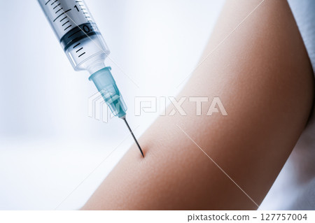 Close up of vaccine injection being administered into child arm showing needle and skin with calm atmosphere and medical focus Close up of vaccine injection being administered into child arm showing needle and skin with calm atmosphere and medical focus 127757004