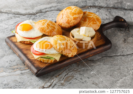 Pineapple Bun Bolo Bao Egg Sandwich with tomato, cheese, lettuce close-up on wooden board. Horizontal Pineapple Bun Bolo Bao Egg Sandwich with tomato, cheese, lettuce close-up on wooden board. Horizontal 127757025