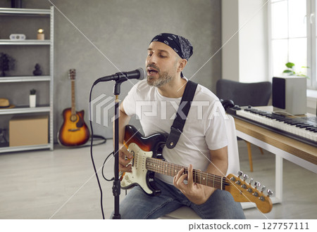 Male musician play guitar sing on microphone 127757111
