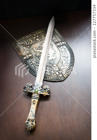Iron shield and sword on the table 127757334