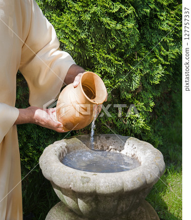 Hands pour water into the pot 127757337