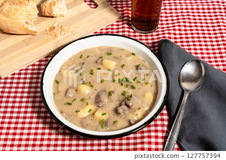 Creamy hungarian chicken paprikash soup with potatoes and dumplings garnished with chives Creamy hungarian chicken paprikash soup with potatoes and dumplings garnished with chives 127757394