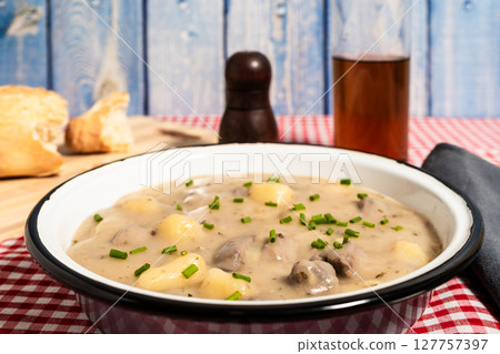 Delicious beef and potato stew garnished with fresh chives served with bread and beer Delicious beef and potato stew garnished with fresh chives served with bread and beer 127757397