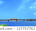 A train running under blue skies and the sea 127757761