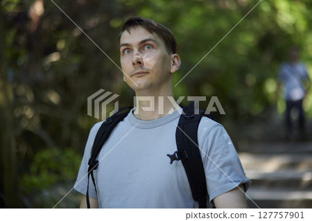 Tourists visit traditional Japanese architecture surrounded by greenery 127757901