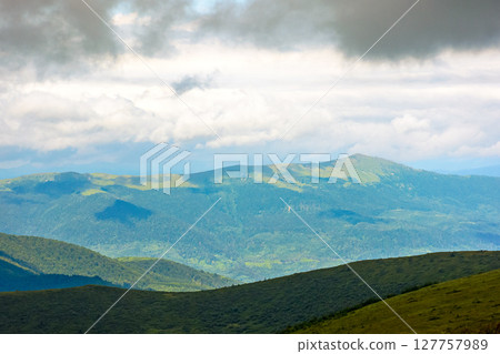 mountain landscape with green pikui peak under storm sky. beautiful summer scenery of carpathian watershed ridge. scenic view of valley in dappled light. outdoor adventure in highland of ulraine mountain landscape with green pikui peak under storm sky. beautiful summer scenery of carpathian watershed ridge. scenic view of valley in dappled light. outdoor adventure in highland of ulraine 127757989