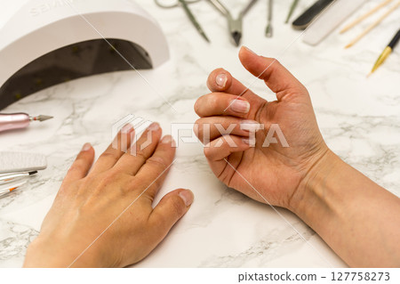 Nail manicure at home, female hands showing her nails. Nail manicure at home, female hands showing her nails. 127758273