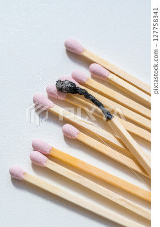 Group of pink matches and one burned match, burnout abstract concept Group of pink matches and one burned match, burnout abstract concept 127758341