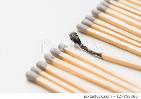 Group of matches and one burned match, burnout abstract concept Group of matches and one burned match, burnout abstract concept 127758360