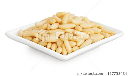 Shelled European pine nuts in ceramic bowl isolated on white background with full depth of field 127758484
