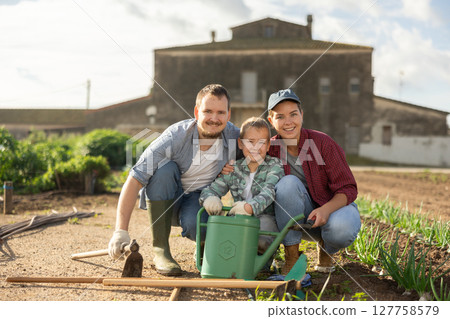Family of farmers standing in the garden 127758579
