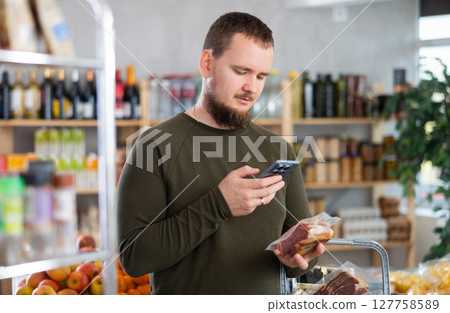 man scans ham in a store 127758589