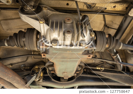This is a closeup view of a cars differential and drive shaft components, showcasing detailed automotive engineering. BMW e30. This is a closeup view of a cars differential and drive shaft components, showcasing detailed automotive engineering. BMW e30. 127758647