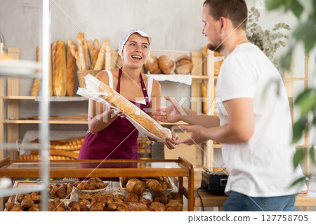 European man visited bakery, communicates with female seller and buy baguettes European man visited bakery, communicates with female seller and buy baguettes 127758705