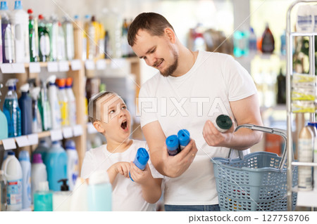 Schoolboy son and dad are choosing trash bags in store 127758706