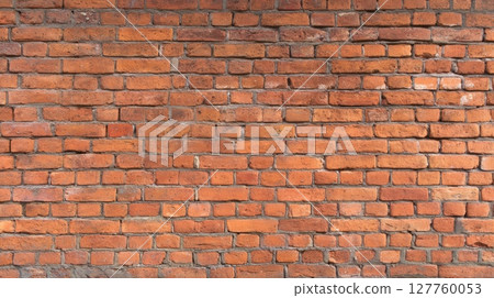 Close-up view of red brick wall with prominent texture and warm lighting. Horizontal alignment creates rhythmic pattern. Background displays muted grout. Neural network AI generated 127760053