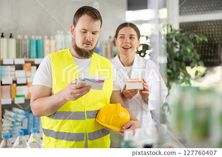 Male builder choosing pills in pharmacy Male builder choosing pills in pharmacy 127760407