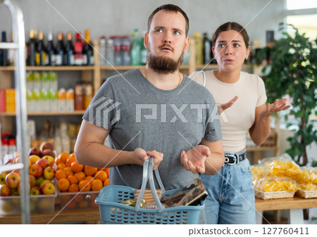 Young woman quarrels with man in grocery store 127760411