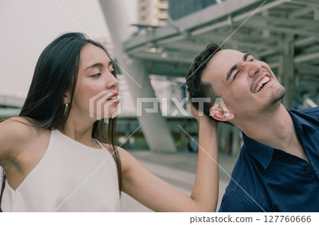 A joyful couple shares a lighthearted moment outdoors, showcasing their playful connection and vibrant energy. A joyful couple shares a lighthearted moment outdoors, showcasing their playful connection and vibrant energy. 127760666
